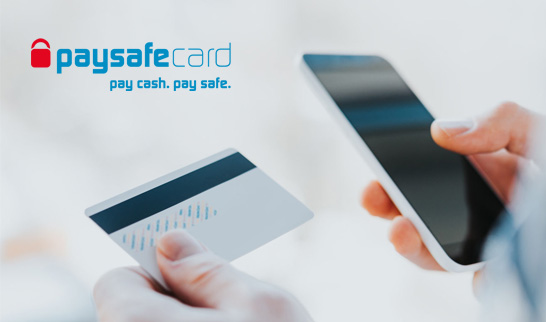 Una persona realiza un pago a través de un móvil con una tarjeta paysafecard