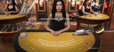 Crupier repartiendo cartas en una mesa de blackjack en vivo en español.