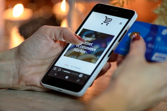 Una mano maneja un teléfono móvil para realizar compras seguras online.