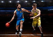 Dos jugadores se disputan la pelota durante un partido de baloncesto.