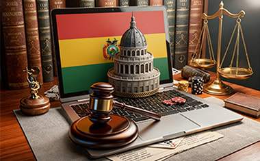 Portátil con una bandera de Bolivia, un mazo judicial y una balanza sobre un escritorio.