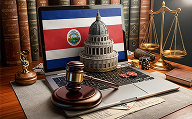 Portátil con una bandera de Costa Rica, un mazo judicial y una balanza sobre un escritorio.