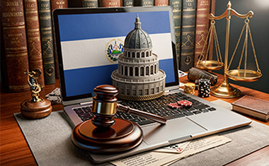 Portátil con una bandera de El Salvador, un mazo judicial y una balanza sobre un escritorio.