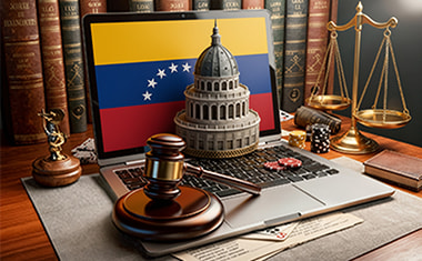 Portátil con una bandera de Venezuela, un mazo judicial y una balanza sobre un escritorio.