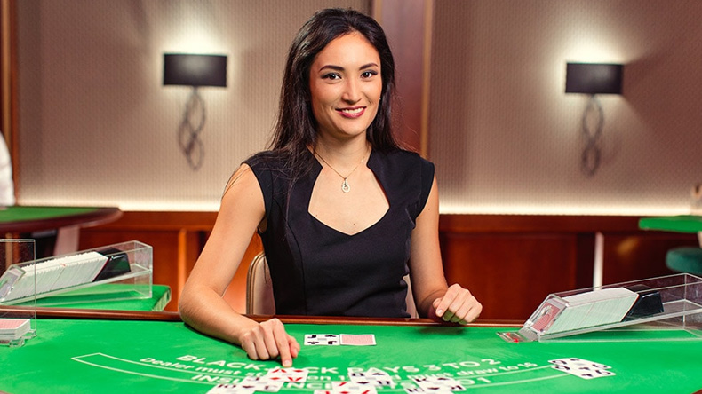 Una crupier en una mesa de blackjack en vivo, disponible en casinos en línea en Guatemala.