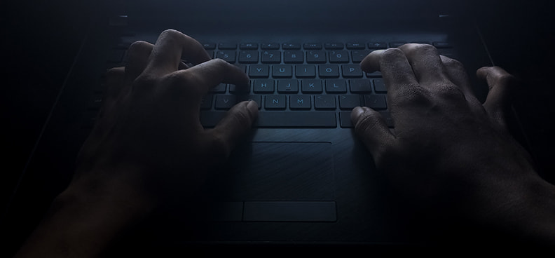 Manos en un teclado cometiendo un fraude de spoofing.
