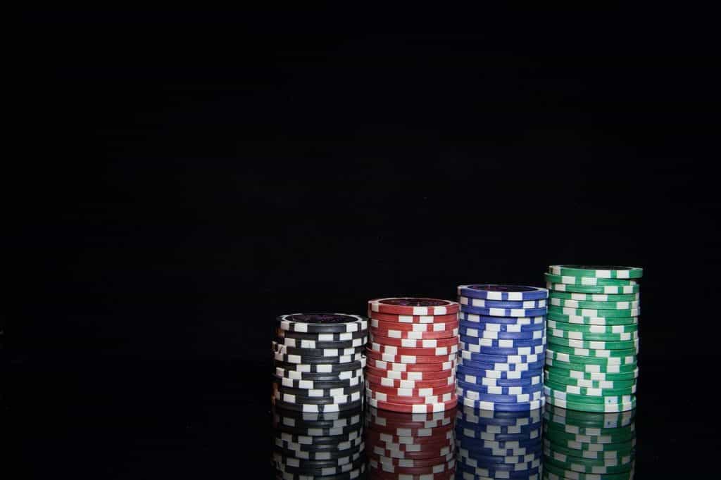 Cuatro pilas de fichas de casino, dispuestas de menor a mayor y ordenadas por colores.