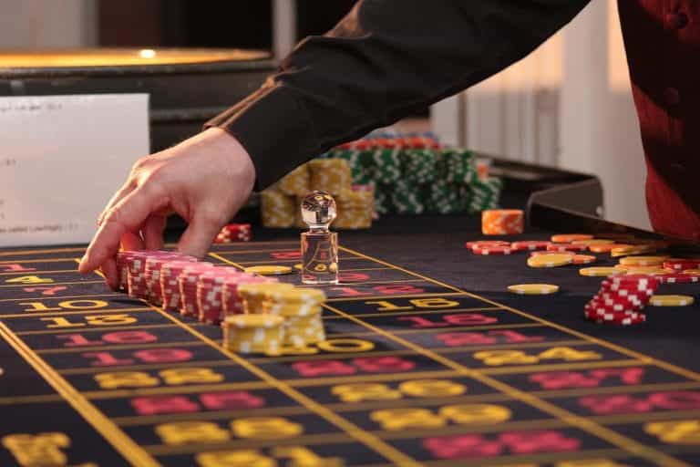 Mesa de ruleta con fichas amarillas y rojas en juego sobre el tapete.