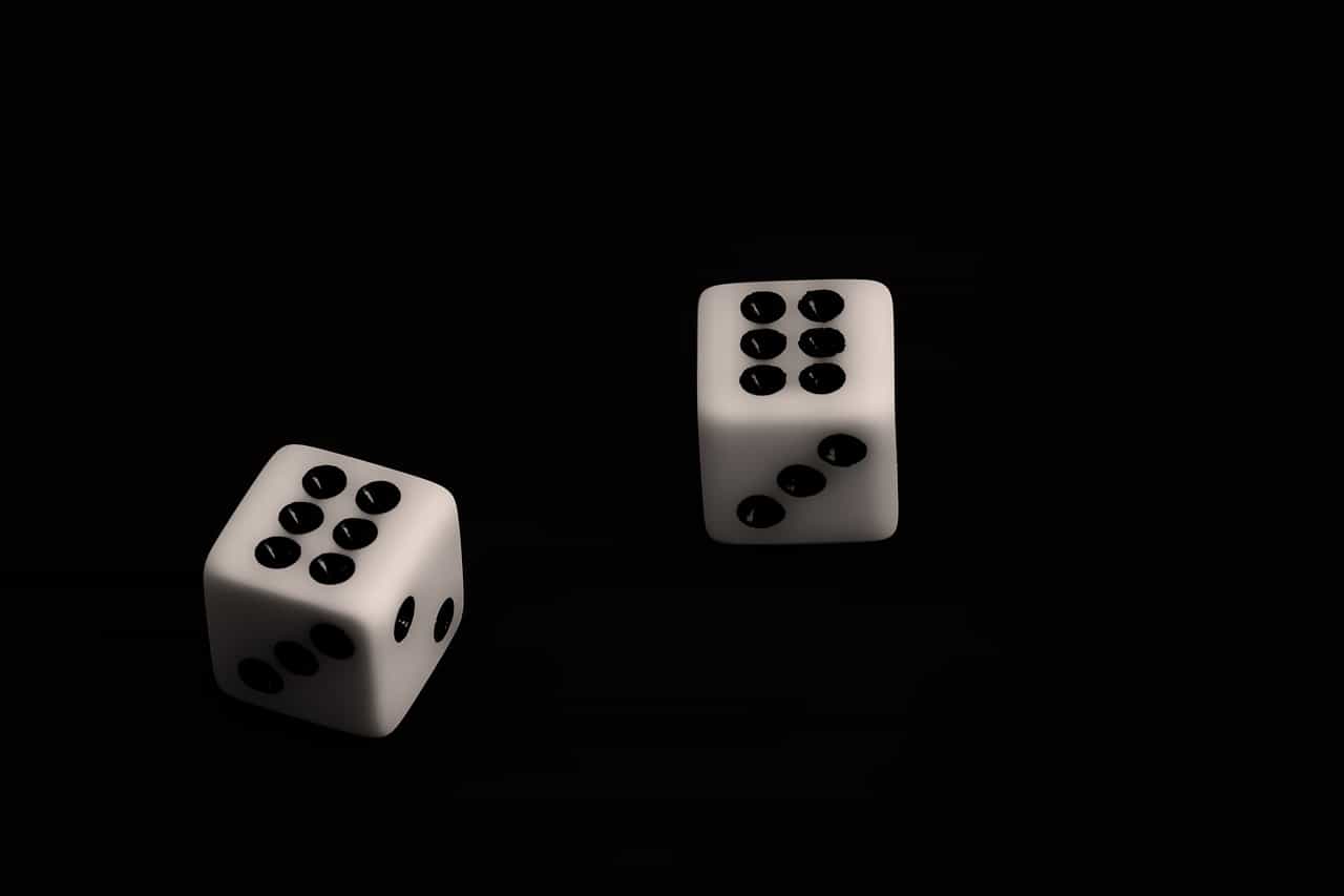 Dos dados sobre fondo negro con el número seis hacia arriba.