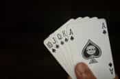 Cartas de póker que muestran la mano 10, J, Q, K, y as de picas.