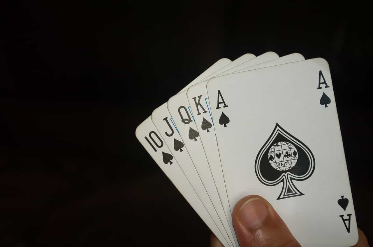 Cartas de póker que muestran la mano 10, J, Q, K, y as de picas. 