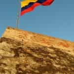 Bandera de Colombia ondeando desde lo alto de un paredón.