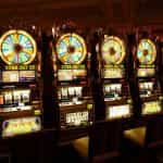 Cinco tragamonedas en hilera dentro de un casino.