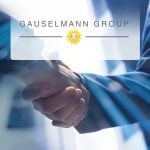 Dos hombres estrechando las manos con el logo del Grupo Gauselmann al frente.