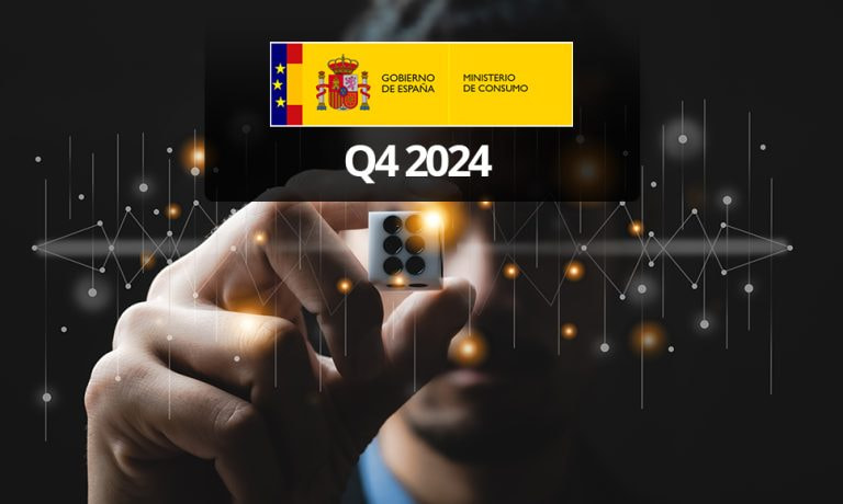 Logo del Ministerio de Consumo en España y una mano sosteniendo un dado entre los dedos.