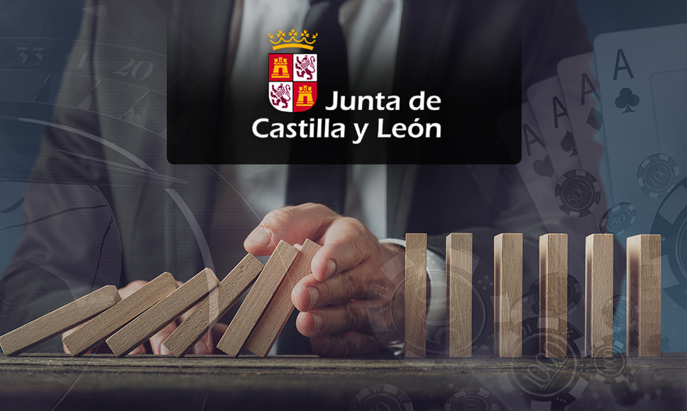 Persona con fichas de madera sobre una mesa y el escudo de Castilla y León.