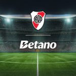 Estadio de fútbol con los logos de la casa de apuestas Betano y el River Plate.