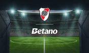 Estadio de fútbol con los logos de la casa de apuestas Betano y el River Plate.