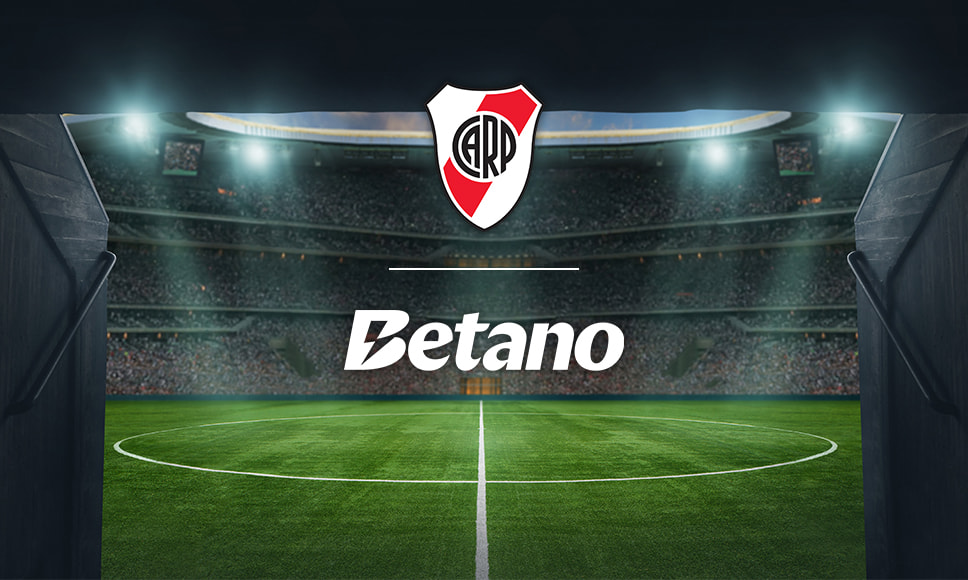 Estadio de fútbol con los logos de la casa de apuestas Betano y el River Plate.