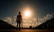 Una tenista con una raqueta sobre una pista de tenis con público.