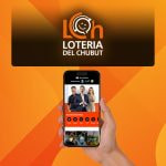 Mano sosteniendo un teléfono con la web de BetWarrior, fondo naranja con el logo de la Lotería del Chubut.