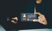 Persona mostrando una identificación digital en una interfaz holográfica para verificar identidad online.