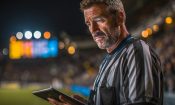 Árbitro de fútbol consultando una tablet en un estadio.