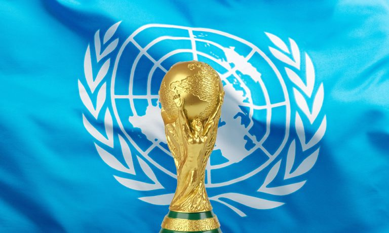 Trofeo de la Copa del Mundo con la bandera de Naciones Unidas detrás.