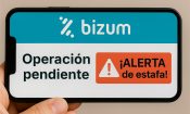 Teléfono móvil mostrando una alerta de fraude en Bizum por solicitud de dinero sospechosa.