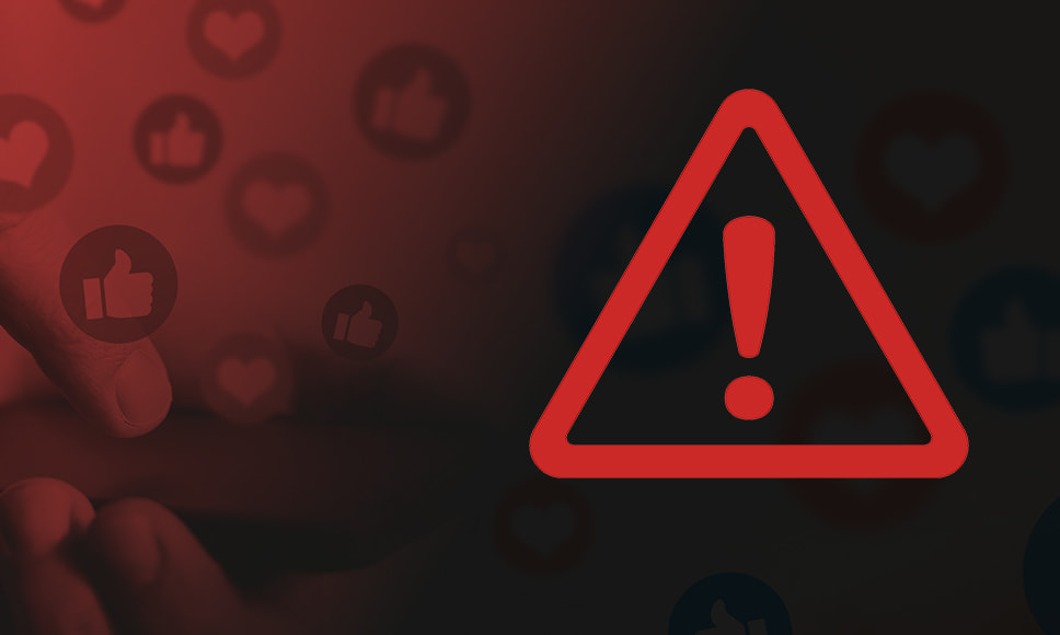 Símbolo de advertencia sobre un fondo con iconos de “me gusta” en redes sociales.