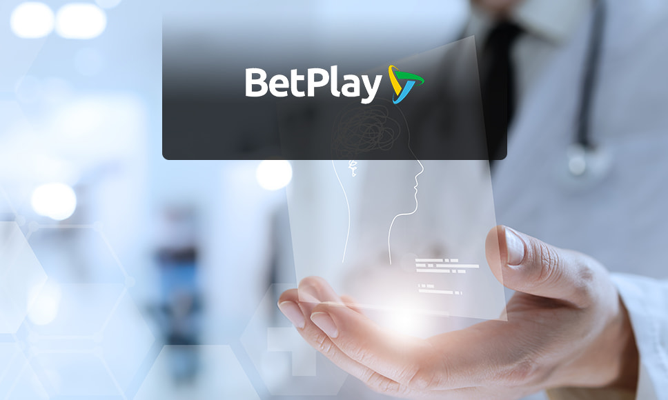 Logotipo de BetPlay sobre fondo médico y mano sosteniendo pantalla digital.