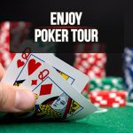 Mano sosteniendo cartas de póker sobre mesa verde con fichas al fondo.