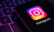 Pantalla de un móvil con el logo de Instagram sobre un teclado iluminado.