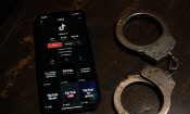 Perfil de TikTok mostrado en un móvil junto a unas esposas sobre una mesa.
