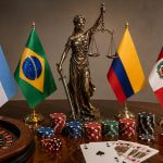 Las banderas de Argentina, Brasil, Colombia y Perú sobre una mesa con fichas de casino, cartas de blackjack y una ruleta.