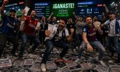 Aficionados de fútbol celebrando eufóricos ante pantallas de apuestas en vivo que marcan ganancias, con carteles de juego responsable en el suelo.