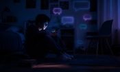 Adolescente sentado a oscuras iluminado por el móvil y rodeado de burbujas de chat, sobre el uso de IA entre menores.