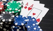 Fichas de casino apiladas y una mano de póker con cuatro ases, sobre la nueva ley de casinos online en Chile.