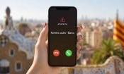 Móvil con una alerta de llamada de número oculto del banco, con el skyline de Barcelona de fondo.