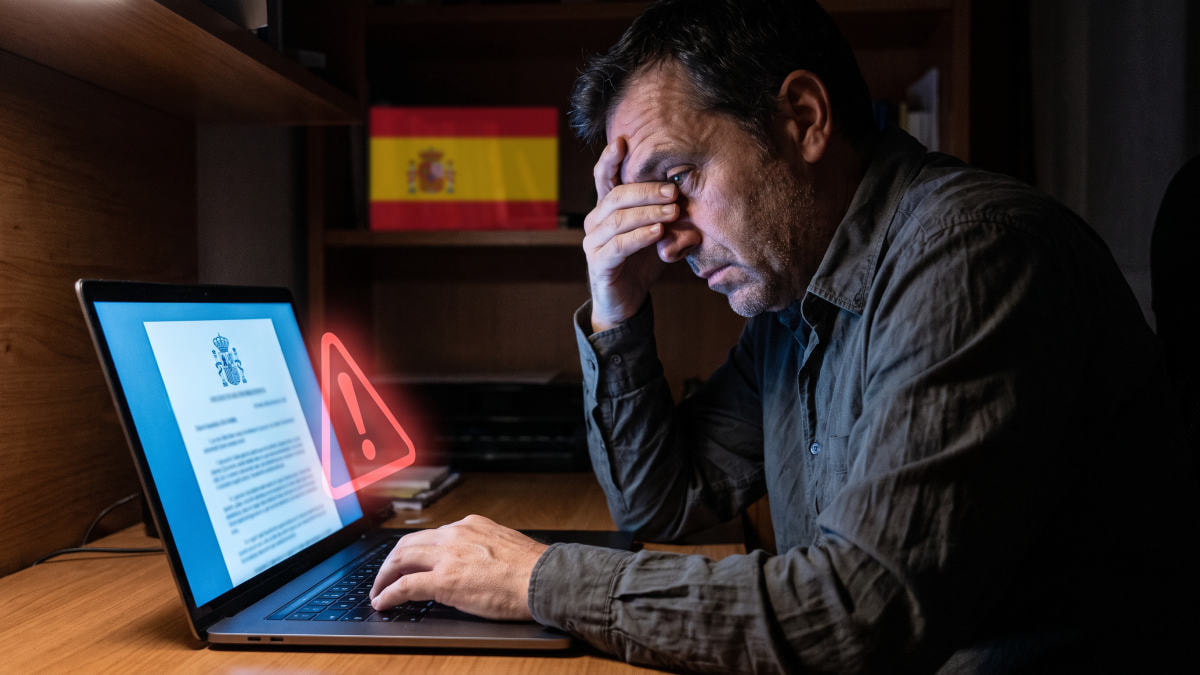 Hombre preocupado ante un portátil que muestra una falsa citación oficial con el escudo de España y una alerta.