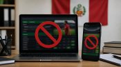 Portátil y móvil mostrando una web de apuestas bloqueada con un símbolo de prohibido, con la bandera de Perú de fondo.
